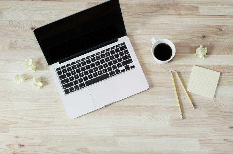 Ordinateur portable, café et bloc-notes sur un bureau en bois